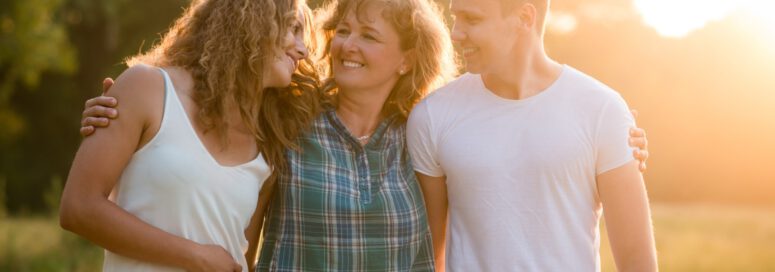 Caucasian family outdoors, spending quality time together. Cheerful happy caucasian family outdoors during summer sunset